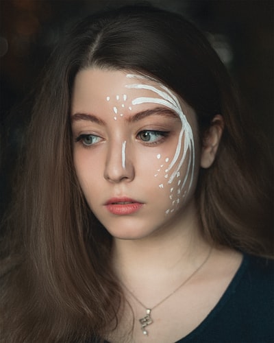 Dressed in black v-neck shirt, ms with silvery white mask
